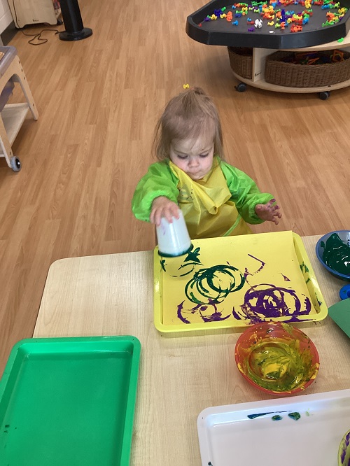 A child painting with a cup.