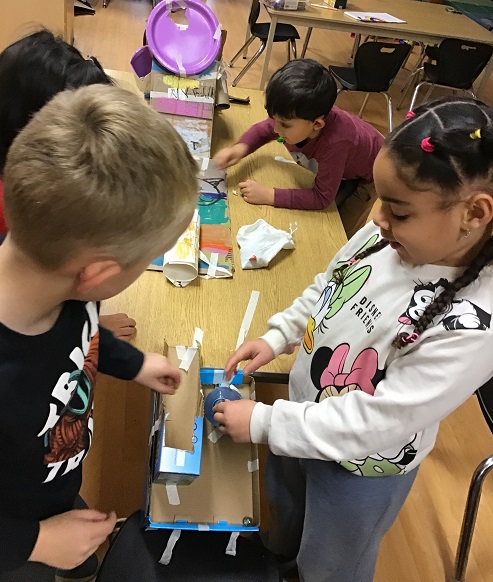 children building a marble run made from recycled materials
