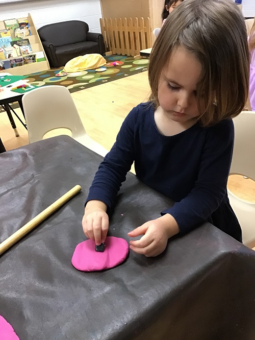 child playing with pink playdough