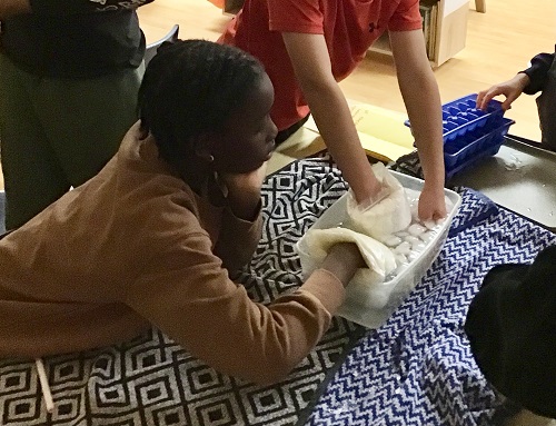 children with hands in ice water