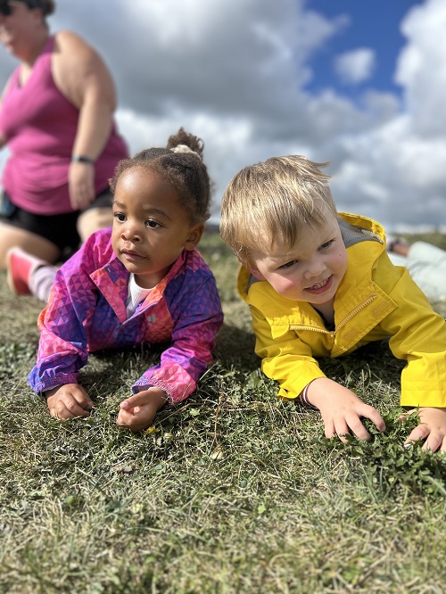 Preschool children laying in the grass