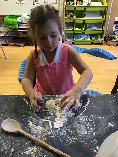 School-age girl moulding playdough