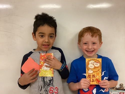 2 children posing with money envelopes