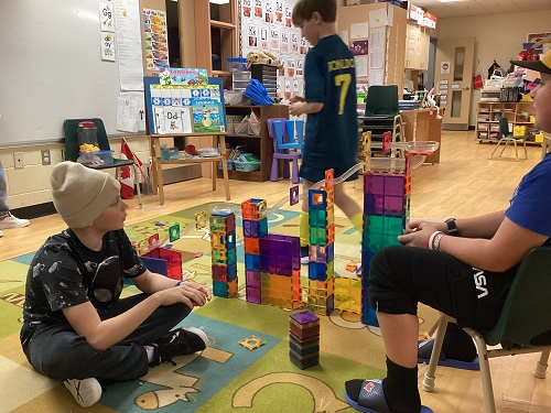 Group of school age boys building marble race track
