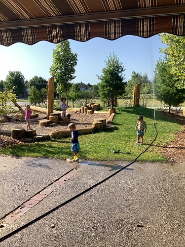 Toddlers playing in sprinkler