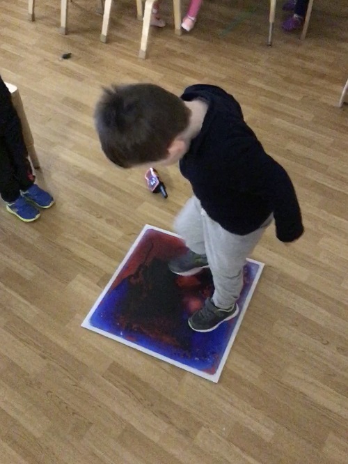 Preschool boy mixes the colours in the sensory mat