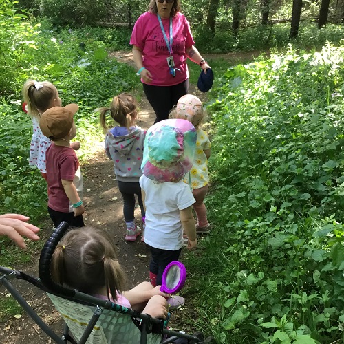 Toddler children on a walk with their educator in the forest