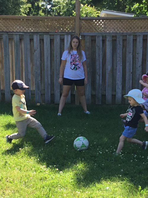 Soccer face off with preschool children and educator