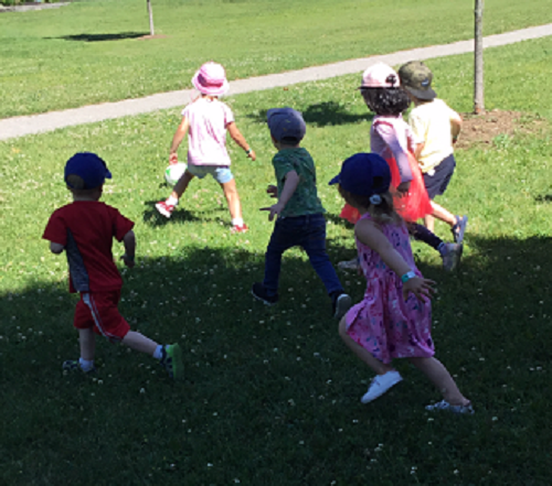 Preschool children playing a game of soccer at the park