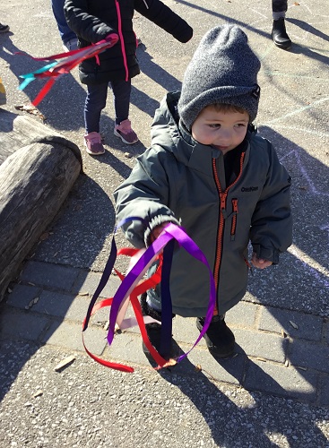 A child holding ribbons outside