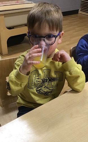 A child having a drink of home made orange juice