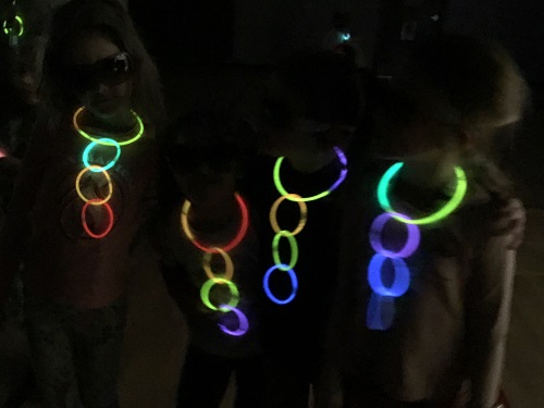 A group of children in the dark with glow necklaces on