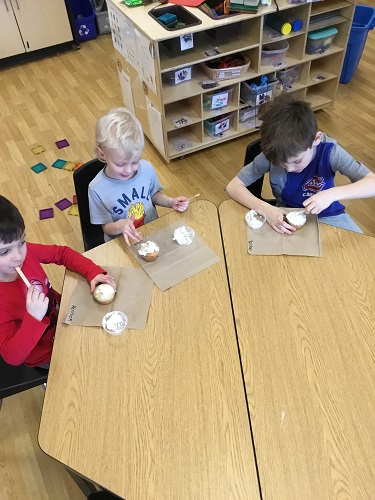 Children sitting around the table eating cupcakes