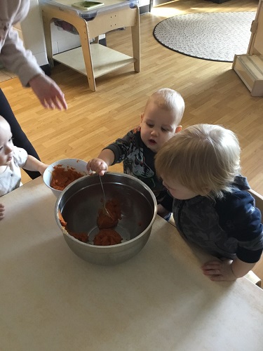 Children helping to scoop ingredients from one bowl to another