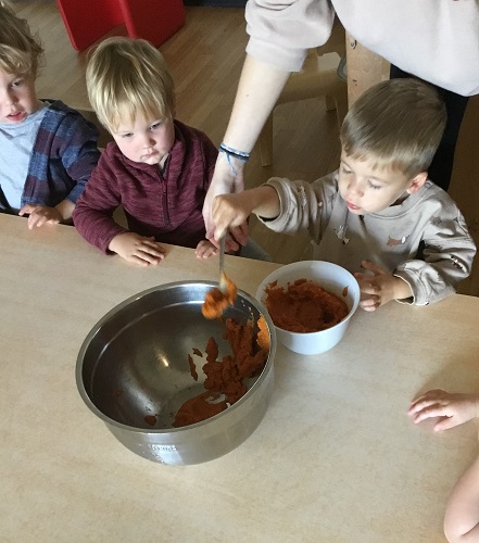 Children helping to scoop ingredients from one bowl to another