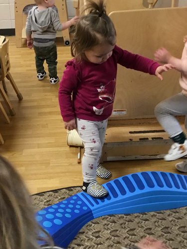 A child taking a step up onto the balancing beam