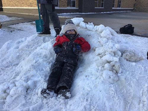A child sitting in a snow bank