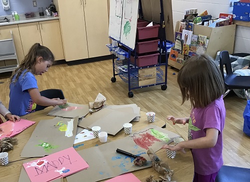 Children at a table finger painting 