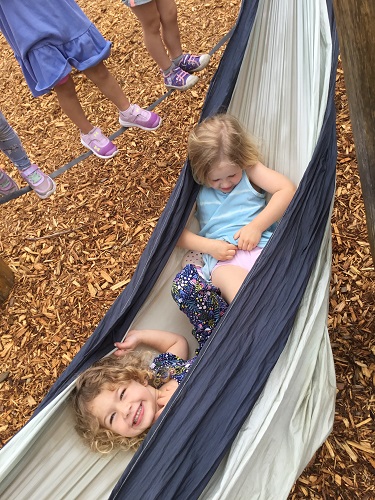 Two children playing in a hammock