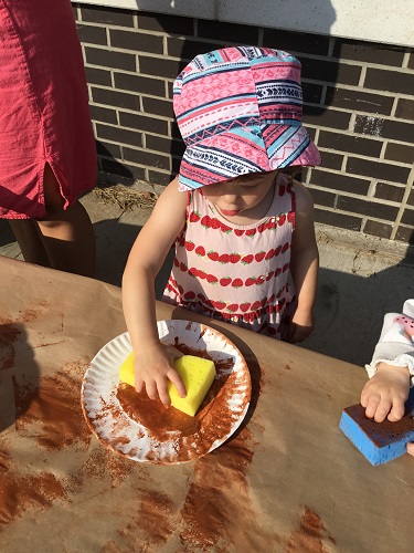 A child painting with a sponge