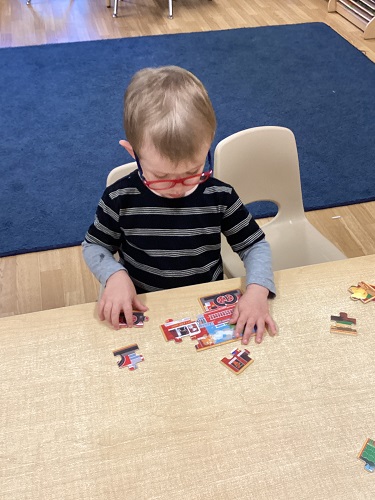 A child sitting at a table working on a puzzle
