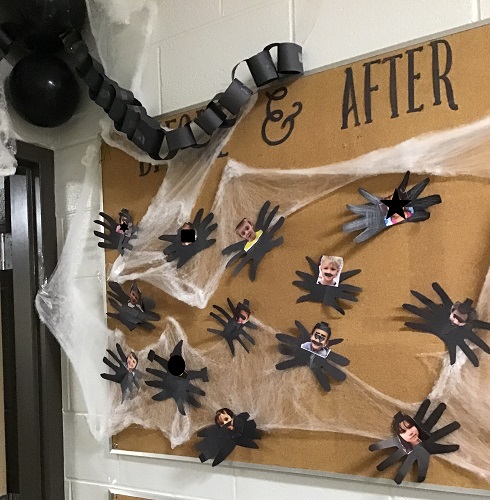 A bulletin board decorated with child-made spiders, webs and a larger spider