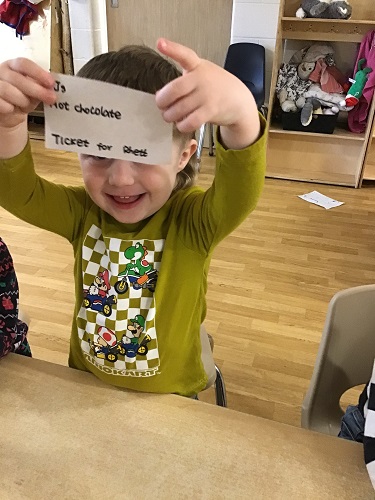 A child holding up their ticket