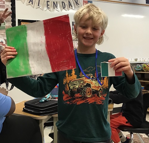 A child holding up a flag they created