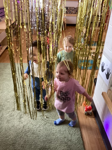 Children exploring the tinsel hanging down