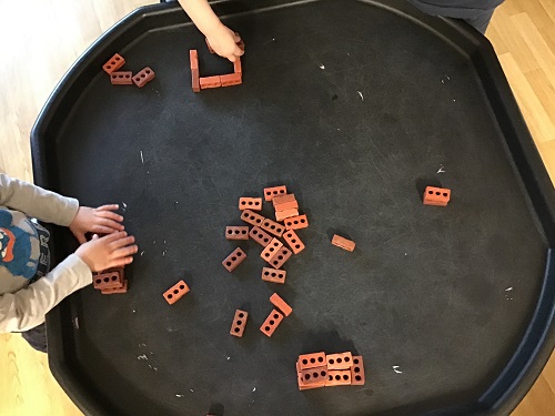Children at the Tuff Tray building houses with the small brick blocks