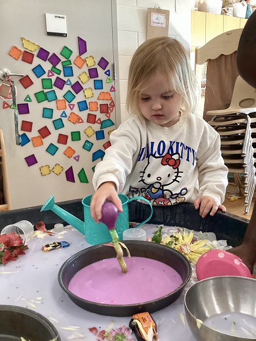 A preschool child using the sensory tray