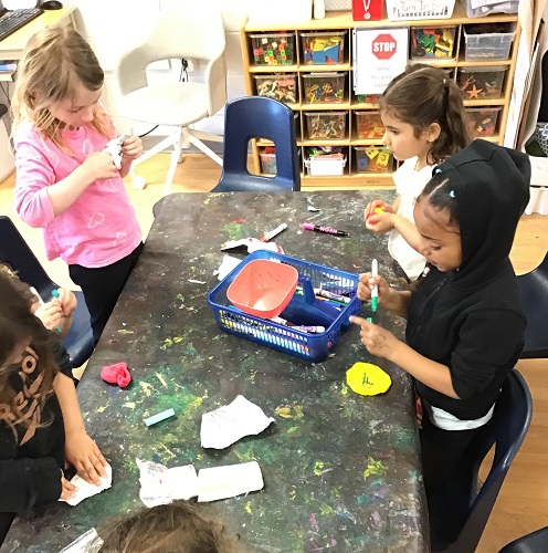 A group of children creating at a table with clay