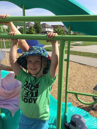 A child swinging on a bar at the park