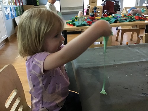 child playing with green slime