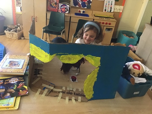 JKK girl playing with homemade puppet theatre