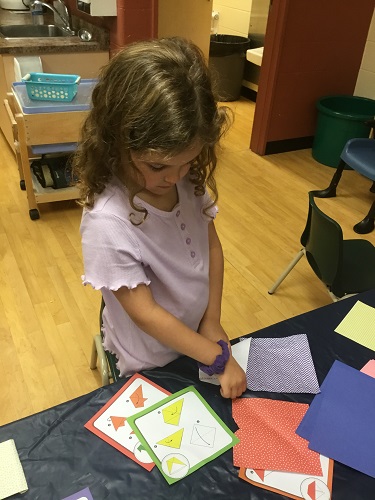 school-age girls choosing origami pattern