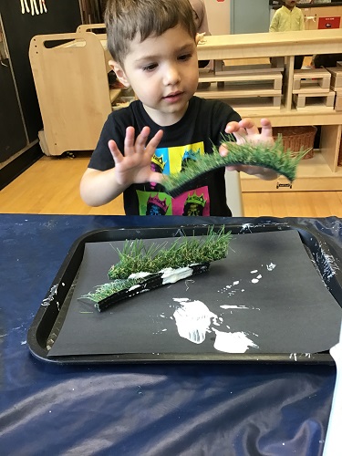 Toddler boy exploring paint and turf