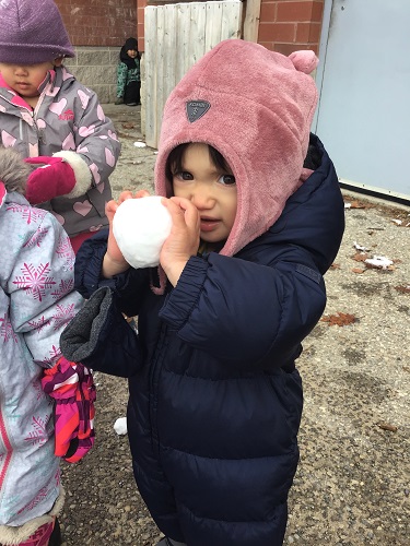 Toddler child holding snowball