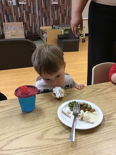 toddler boy licking whipped cream off pumpkin tart