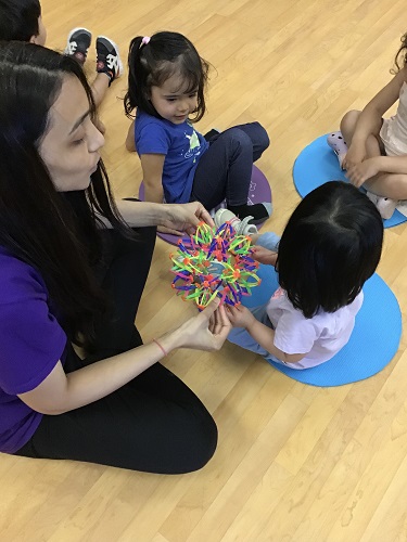 Toddlers engaging in yoga and breathing ball