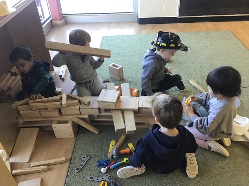 Group of preschool building pirate ship with blocks