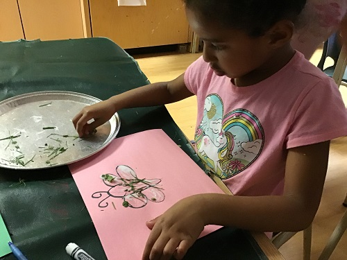 JK girl using grass to make butterfly wings 