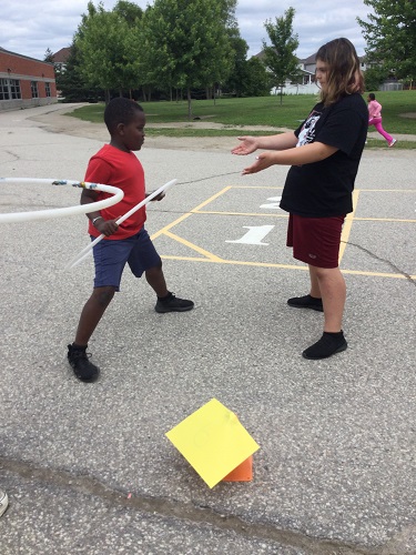 2 school-age children competing in hoola hoop task