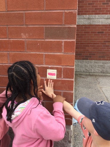 school-age girl about to press emergency button in game