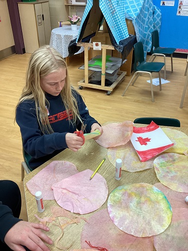 school-age girl cutting leaves out of filter