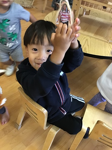 Toddler boy showing block with real picture on it