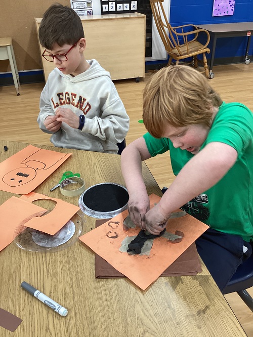 2 school age children working on a creative experience