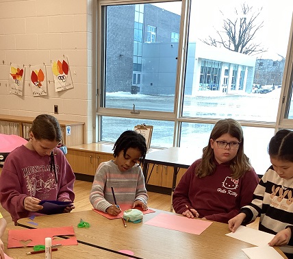 a group of 4 school age children working on a creative experience