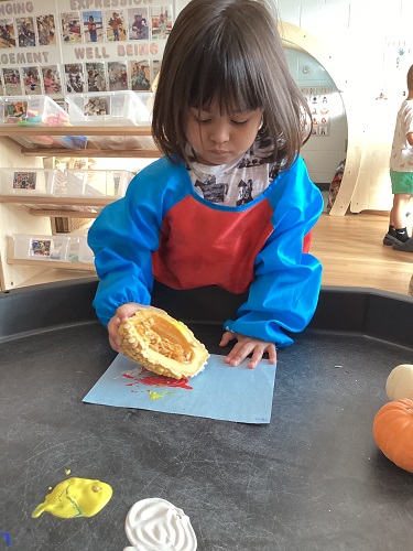 Child examines an open pumpkin