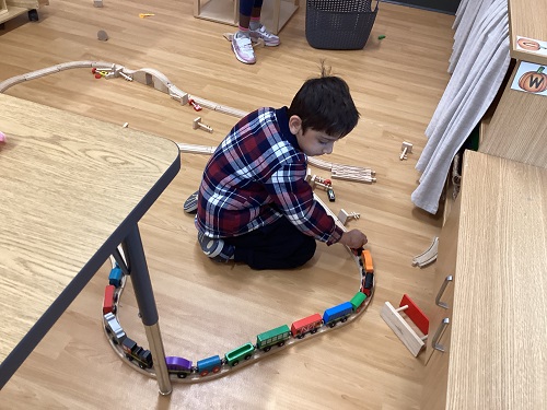 A child plays with trains on a track
